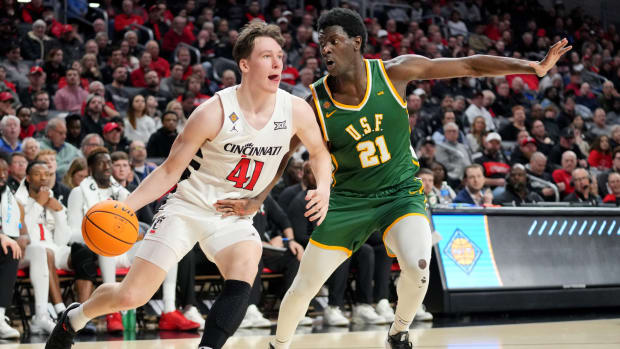 Cincinnati Bearcats guard Simas Lukosius (41) drives to the basket as San Francisco Dons forward Ndewedo Newbury (21) defends in the second half of a college basketball game in the National Invitation Tournament, Wednesday, March 20, 2024, at Fifth Third Arena in Cincinnati.  